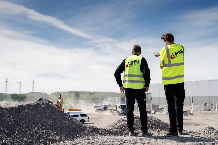 Två markentreprenörer diskuterar ett gräv- och markprojekt.